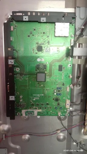 Technician fixing a display issue on a large screen TV